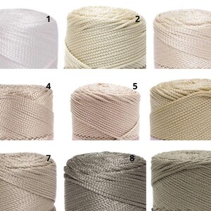 May include: Nine spools of nylon cord in a range of neutral shades. The spools are numbered 1 to 9, with colours from white to beige, tan, and grey. The cord has a woven texture, suitable for crafting and macram&eacute; projects.