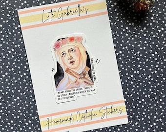 May include: A sticker featuring a watercolor illustration of Saint Rose of Lima, a Catholic saint. The sticker has a white background with a quote from Saint Rose of Lima: "Apart from the cross, there is no other ladder by which we may get to heaven."