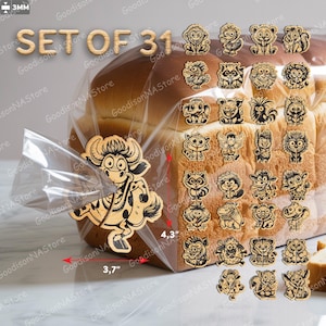 Op de afbeelding: Een set van 31 houten zakclips in de vorm van dieren. De lasergesneden clips hebben verschillende cartoon dierenontwerpen. De grootste clip, een stier, is 9,4 cm breed en 10,9 cm hoog. De clips worden getoond met een brood.