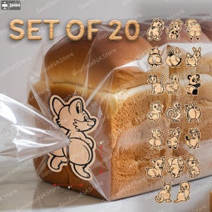 Op de afbeelding: Een set van 20 houten dierenfiguren, elk met een uniek ontwerp, gepresenteerd in een doorzichtige plastic zak. De figuren zijn ongeveer 7.6 cm breed en 10.2 cm hoog. De tekst "SET OF 20" is zichtbaar.