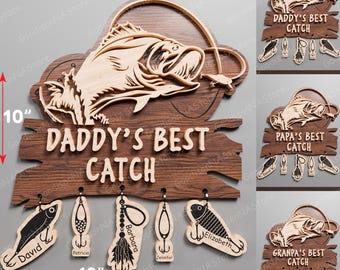 May include: A wooden sign with a carved fish and the text "Daddy's Best Catch". The sign has five hooks with personalized fishing lures hanging from them. The lures are labeled with names like "David", "Patricia", "Barbara", "Jennifer", and "Elizabeth".