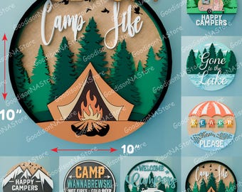 May include: Set of seven 10-inch round wooden signs with a camping theme. The signs feature various designs, including a campfire scene, a camper van, and text that says "Camp Life", "Happy Campers", "Gone to the Lake", "Welcome Campers", "Camp Wannabrewski", and "Beach Please".