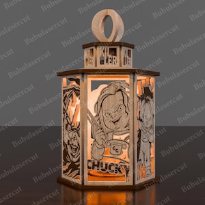 May include: A wooden lantern with laser-cut horror movie character designs. The lantern features a handle, and the word "CHUCKY" is visible on the front panel. The design includes images of Chucky and other characters.
