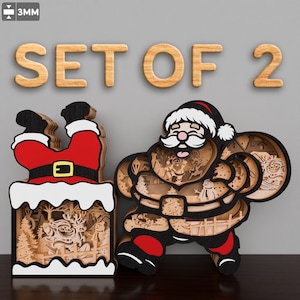 Op de afbeelding: Set van twee lasergesneden houten kerstversieringen. Eén toont Sinterklaas met een zak vol cadeaus, de andere toont Sinterklaas vast in een schoorsteen. Beide zijn ingewikkeld gedetailleerd en hebben een rustieke houten afwerking.