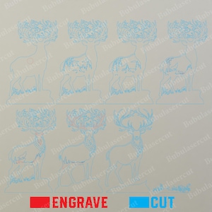 May include: Seven light blue laser-cut deer silhouettes with intricate antler designs and varying forest-themed cutouts on their bodies. A small red circle is on one deer. Below, red text reads ENGRAVE and blue text reads CUT, indicating laser settings.