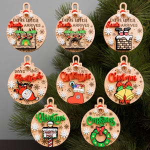 Può includere: Sette decorazioni natalizie in legno con disegni festivi. Ogni decorazione, con sfondo marrone chiaro, mostra la scritta "25 giorni a" insieme a immagini natalizie. I disegni includono Babbo Natale, calze, campane e un cartello del Polo Nord.