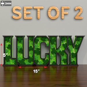 May include: Set of two 5-inch tall wooden "LUCKY" signs with a green shamrock pattern. Each sign is 15 inches wide.