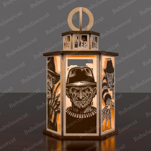 May include: A wooden lantern featuring laser-cut images of Freddy Krueger from the Nightmare on Elm Street films. The lantern has a hexagonal shape with the word "KILLER" cut out at the top. The design includes detailed character portraits.