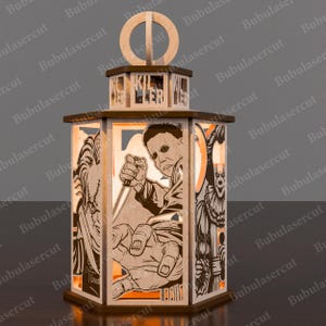 May include: A wooden Halloween-themed lantern featuring laser-cut images of horror movie characters. The lantern has a hexagonal base and top with the word "KILLER" cut out. The images include a figure holding a knife. The lantern is made of light-colored wood.