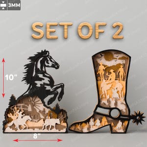 Peut inclure: Ensemble de deux décorations murales en bois découpées au laser. Une pièce représente un cheval se dressant sur ses pattes arrière, l'autre une botte de cowboy. Les deux pièces mesurent 25,4 cm de haut et 20,3 cm de large. La pièce représentant le cheval présente une scène western avec un cowboy qui lâche un lasso sur un bœuf. La pièce représentant la botte présente une scène western avec des cowboys à cheval.