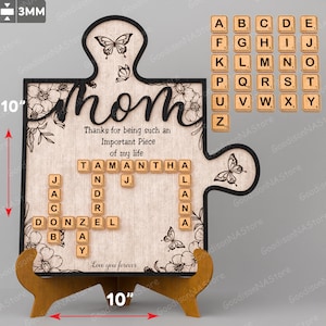 May include: A wooden puzzle piece shaped like a heart with the word "Mom" written in cursive. The puzzle piece has a floral design and a scrabble tile message that reads "Thanks for being such an Important Piece of my life." The message is spelled out with the letters "TAMANTHA". The puzzle piece is 10 inches wide and 10 inches tall.