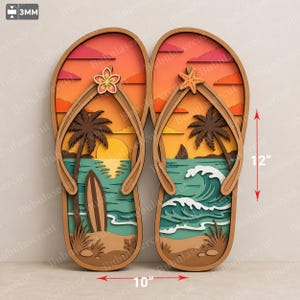 Pode incluir: Um par de decorações de parede de madeira em camadas em forma de chinelos com uma cena de pôr do sol na praia, palmeiras, uma prancha de surf, um veleiro e ondas. O chinelo esquerdo tem uma flor, o direito uma estrela do mar. 30,48 cm por 25,4 cm.