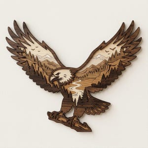 May include: A multi-layered wooden wall art piece shaped like a soaring eagle. The design features a dark brown wood silhouette of an eagle with a cutout center revealing a light-colored wood landscape of mountains, a winding river, and pine trees.