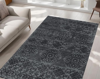 Könnte beinhalten: Ein grauer Teppich mit einem sich wiederholenden Muster aus stilisierten Blumen und geometrischen Formen. Der Teppich hat einen abgenutzten, Vintage-Look.