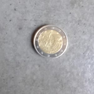 May include: A silver and gold coloured Euro coin with a design of a map of Europe and the words "EUROPA" and "2002" on it.