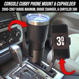 May include: A black console cubby phone mount and cupholder for 2005-2007 Dodge Magnum, Dodge Charger, and Chrysler 300. The image shows a black tumbler in a cupholder and a phone mounted with the text "3DW" on the phone screen.