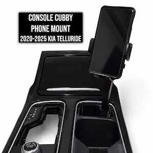 May include: A black console cubby phone mount for a 2020-2025 Kia Telluride, featuring a vertical arm extending from the centre console to hold a smartphone. The text CONSOLE CUBBY PHONE MOUNT 2020-2025 KIA TELLURIDE is displayed in white on a black background.