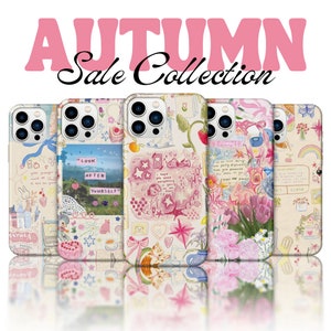 May include: A collection of phone cases with whimsical designs. The cases feature pastel colors, illustrations of flowers, stars, and text, including "AUTUMN Sale Collection" and "LOOK AFTER YOURSELF". The cases are displayed on a reflective surface.