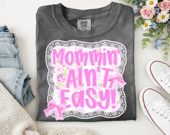 Mommin’ Ain’t Easy – Pink Floral & Bow Graphic Mom Shirt