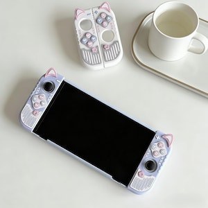 Könnte beinhalten: Eine weiße Keramik-Tasse mit schwarzem Henkel und dem Text "But First, Coffee" in fetter, schwarzer Schrift. Die Tasse steht auf einer Holzoberfläche. Die Tasse fasst etwa 355 ml.