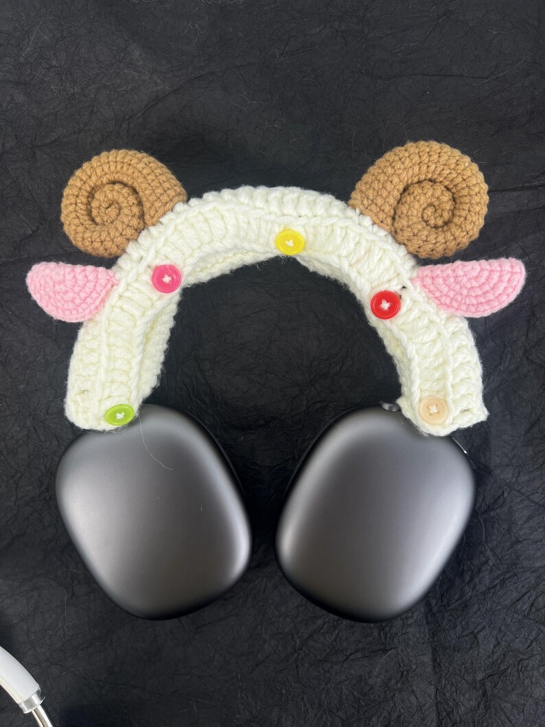 Peut inclure: Bandeau en crochet blanc avec des oreilles brunes et roses et des boutons color&eacute;s. Le bandeau est con&ccedil;u pour s'adapter sur des &eacute;couteurs.