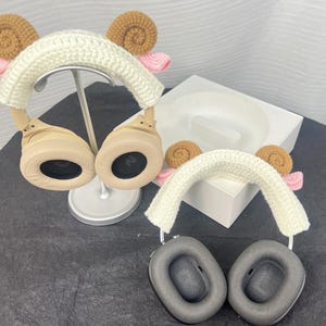 Peut inclure: Deux paires de casques avec des housses en crochet. Les housses sont blanches avec des accents bruns et roses. Les &eacute;couteurs sont beiges et noirs.
