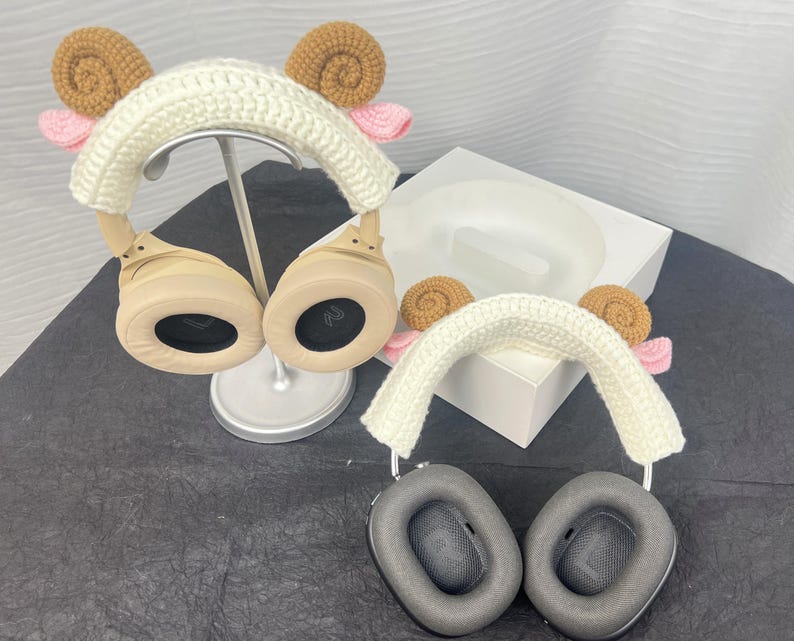 Peut inclure: Deux paires de casques avec des housses en crochet. Les housses sont blanches avec des accents bruns et roses. Les &eacute;couteurs sont beiges et noirs.