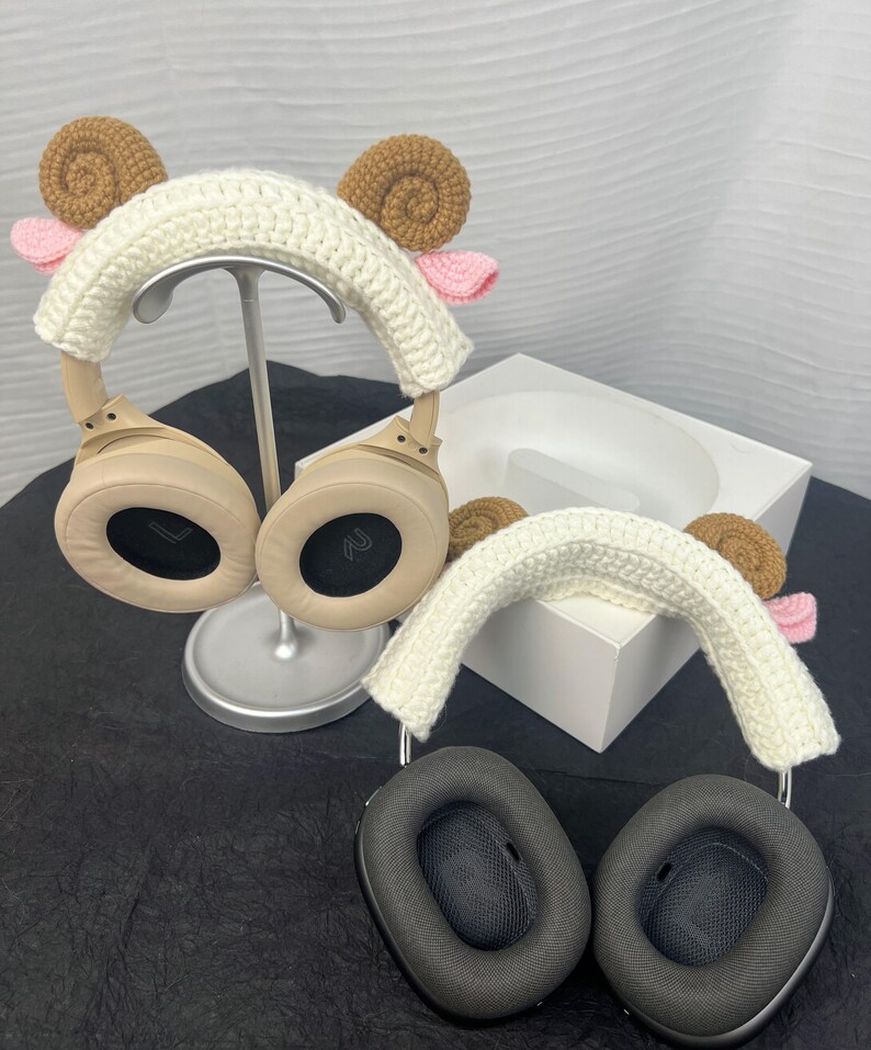 Peut inclure: Deux paires de casques avec des bandeaux en crochet en forme de t&ecirc;te de mouton. Les bandeaux sont blancs avec des oreilles brunes et des nez roses. Les casques sont beige et noirs.