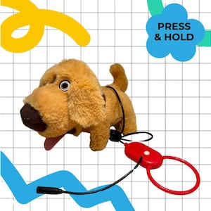May include: A plush, golden-brown toy dog with a black leash and a red handle. The dog has a brown nose, a pink tongue, and the text "PRESS & HOLD" in a blue cloud shape.