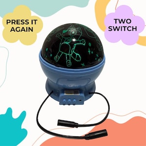 以下が含まれることがあります： 青いナイトライトプロジェクター。黒いドームには、漫画のキャラクターと緑色の星が表示されています。ベースにはコントロールパネルと2本の黒いコードがあります。画像には「PRESS IT AGAIN」と「TWO SWITCH」というテキストが表示されています。