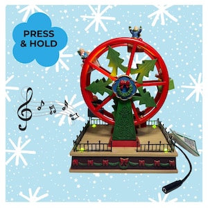 May include: A red and green Christmas ferris wheel decoration featuring small figures in seats, green tree-shaped spokes, and a central wreath. The base has a black fence, small lights, and a power cord. A blue cloud graphic says PRESS & HOLD.