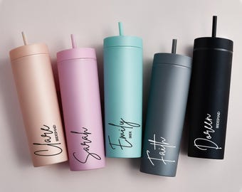 May include: Five personalized tumblers in pastel colors: blush, pink, teal, gray, and black. Each tumbler has a name in a cursive font. The blush tumbler says "Clare Bridesmaid". The teal tumbler says "Emily Bride".
