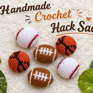 Puede incluir: Sacos de hacky hechos a mano con ganchillo, con forma de béisbol, baloncesto y fútbol americano. Las pelotas de béisbol son blancas con costuras rojas, las de baloncesto son naranjas con líneas negras y las de fútbol americano son marrones con costuras blancas. El texto dice "Handmade Crochet Hack Sack".