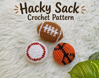 Könnte beinhalten: Drei gehäkelte Hacky Sacks in Form von Sportbällen, darunter ein brauner Football mit weißen Schnürsenkeln, ein weißer Baseball mit roten Nähten und ein orangefarbener Basketball mit schwarzen Linien. Der Text Hacky Sack Crochet Pattern ist sichtbar.