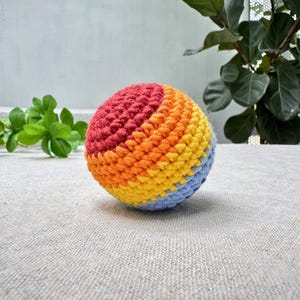 Rainbow swirl crochet hacky sack pattern, colorful amigurumi footbag with red orange yellow blue stripes, beginner PDF