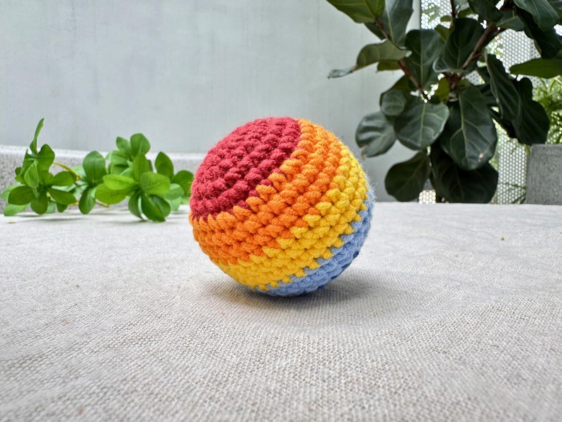 Rainbow swirl crochet hacky sack pattern, colorful amigurumi footbag with red orange yellow blue stripes, beginner PDF