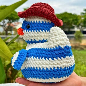 Pu&ograve; includere: Bambola pinguino all'uncinetto fatta a mano con cappello rosso, corpo a righe blu e bianche e becco arancione. Il morbido peluche &egrave; adatto ai bambini o come oggetto decorativo. Il pinguino &egrave; un oggetto unico, fatto a mano.