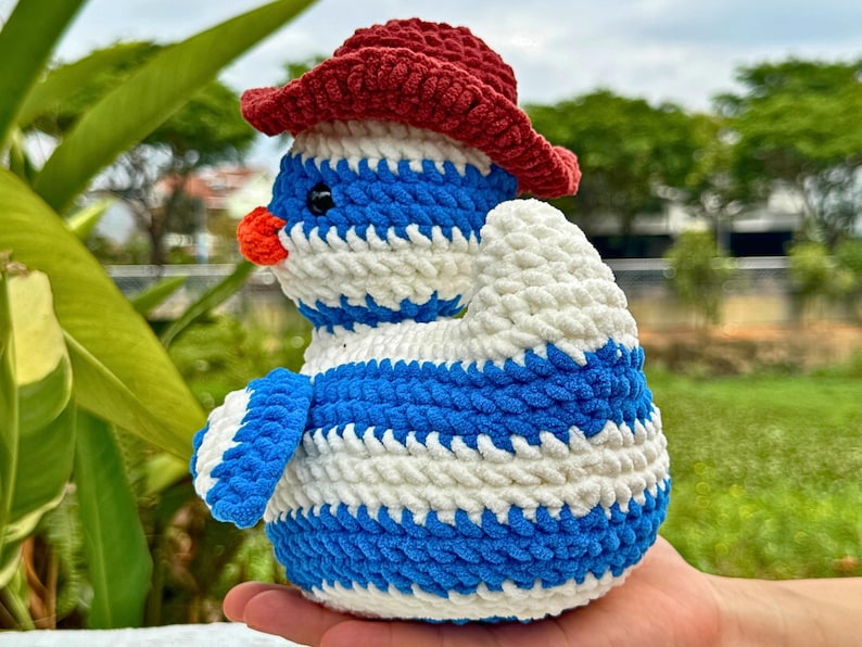 Pu&ograve; includere: Bambola pinguino all'uncinetto fatta a mano con cappello rosso, corpo a righe blu e bianche e becco arancione. Il morbido peluche &egrave; adatto ai bambini o come oggetto decorativo. Il pinguino &egrave; un oggetto unico, fatto a mano.