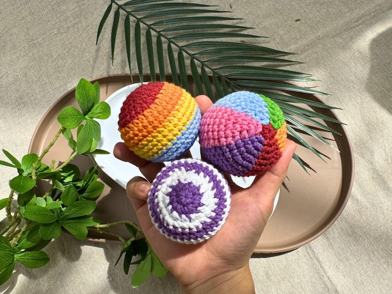 Crochet hacky sack pattern bundle showing 3 rainbow amigurumi balls - rainbow swirl, patchwork, and purple spiral designs