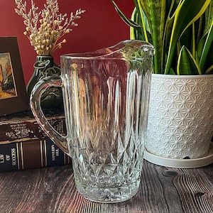 May include: A rustic wooden sign with the text "Welcome to our home" in white lettering. The sign features a distressed finish and a simple, inviting design, perfect for a front porch or entryway.