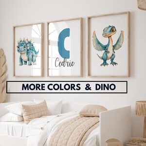 Può includere: Tre stampe incorniciate con un tema di dinosauro blu. La prima stampa presenta un dinosauro blu con punte sulla schiena. La seconda stampa presenta una lettera C blu e il nome Cedric. La terza stampa presenta un dinosauro blu con le ali spiegate.