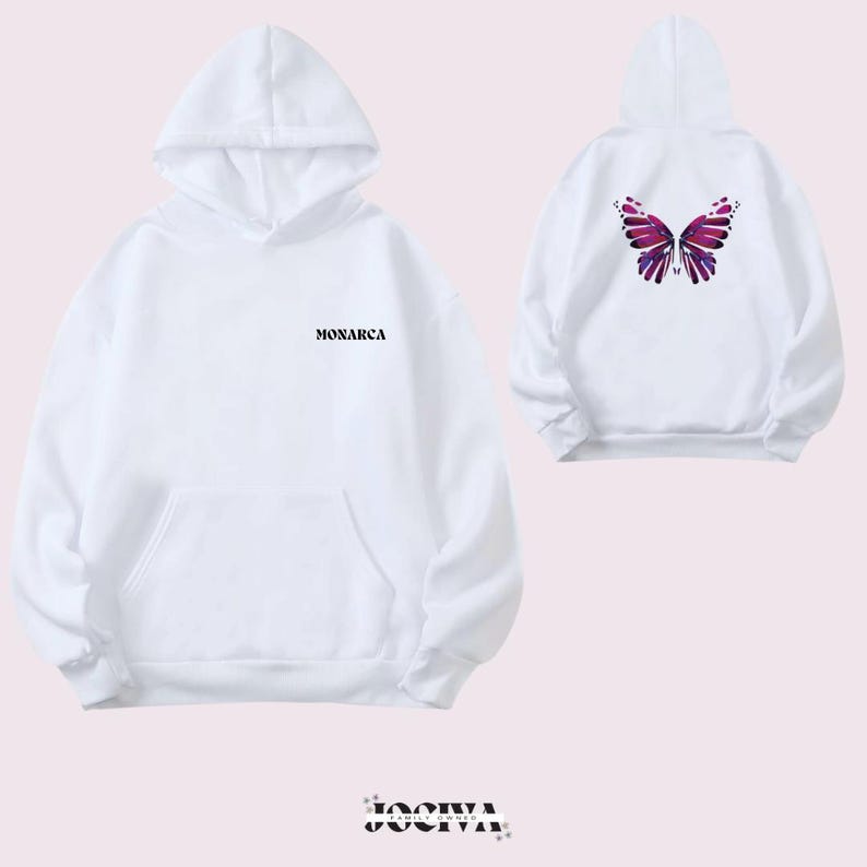 Puede incluir: Sudadera blanca con bolsillo delantero y capucha. La parte delantera presenta la palabra "MONARCA" en negro. La parte trasera de la sudadera muestra un dise&ntilde;o de mariposa en tonos morados y rosas. Es una prenda casual.