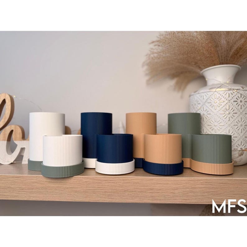 a variety of colorful vases and containers arranged on a wooden shelf, with a decorative vase and some dried plants in the background.