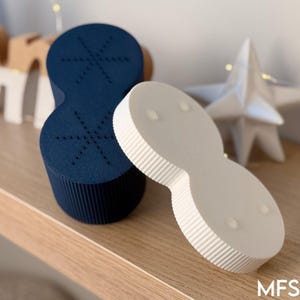 a wooden shelf with various objects, including a blue and white object, a white star-shaped object, and a white star-shaped object.