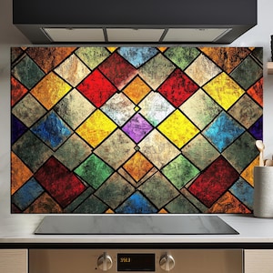 May include: A colorful stained glass style kitchen backsplash with a geometric pattern of squares and diamonds in shades of red, yellow, blue, green, and purple. The backsplash is installed above a stainless steel oven with a digital display.