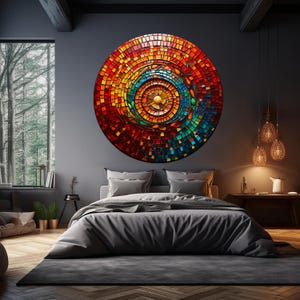 May include: A large circular wall art piece with a mosaic design. The mosaic is made up of small squares of glass in shades of red, orange, yellow, green, blue, and brown. The center of the mosaic is a gold circle. The mosaic is hanging on a dark gray wall in a bedroom setting.