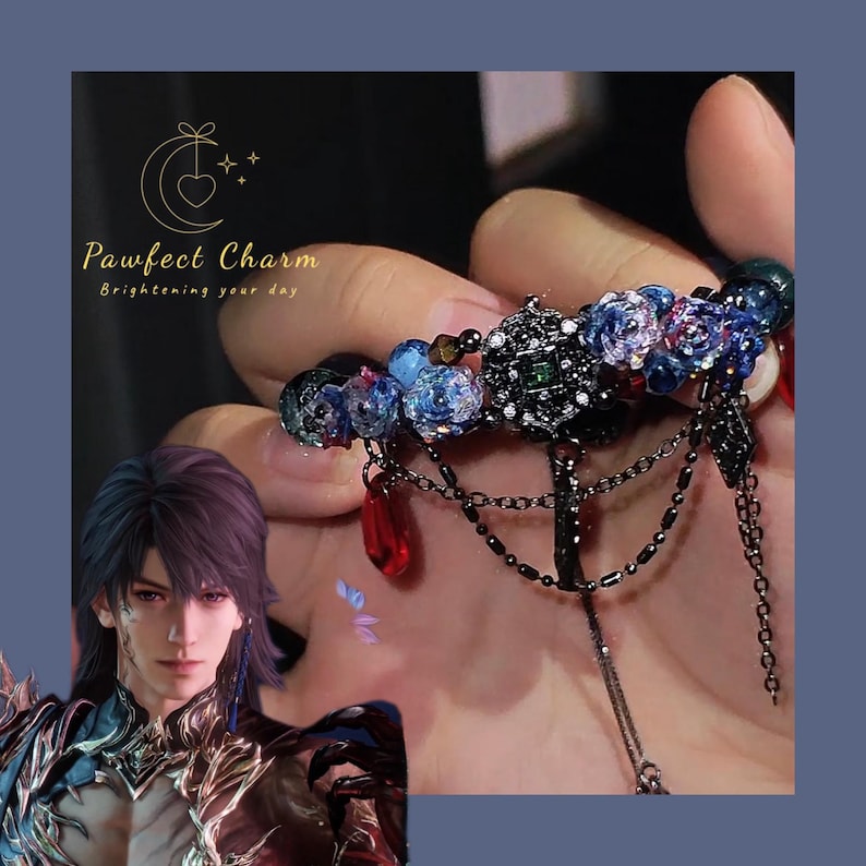 May include: An ornate, dark metal nail accessory with blue floral accents, red teardrop charms, and dangling chains. The accessory is held up by a hand. The image also includes the text "Pawfect Charm" and a graphic of a person.