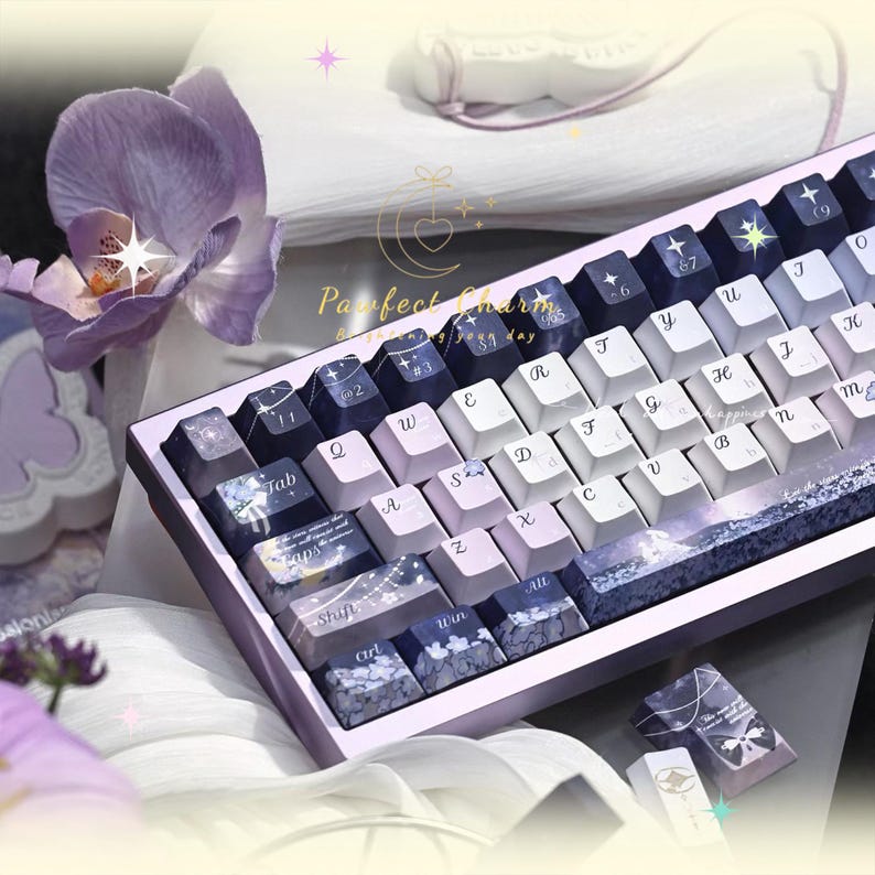 May include: A custom mechanical keyboard with a purple and white color scheme. The keycaps feature a mix of white, lavender, and dark blue keys with various designs. The keyboard has a matching purple frame and the text "Perfect Charm" is visible.