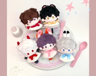 May include: A collection of plush dolls with various hair colors and accessories, including horns, cat ears, and bunny ears. Each doll is dressed in a white outfit with a colored bow. Pink fork and spoon are included.