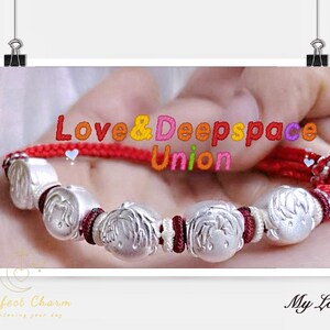 May include: A silver bracelet with a red cord and decorative silver beads. The beads have a design of a person's face. The text "Love & Deepspace Union" is visible in the image.